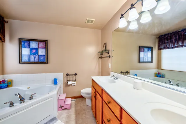 a bathroom with a tub sink and mirror