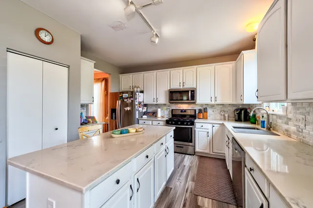 a kitchen with white cabinets and stainless steel appliances