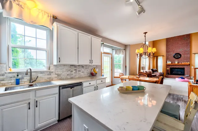 a large kitchen with sink a counter space and living room