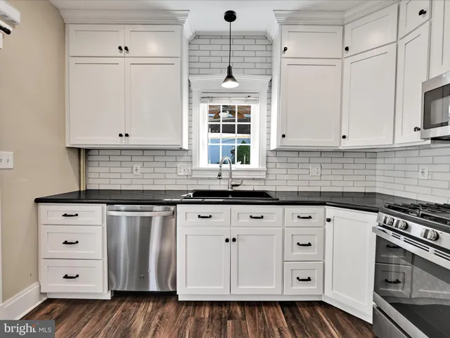 a kitchen with granite countertop white cabinets and white appliances