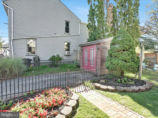 a view of a house with a small yard and wooden fence