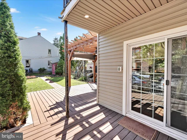 a view of a patio with table and chairs and wooden floor next to a yard