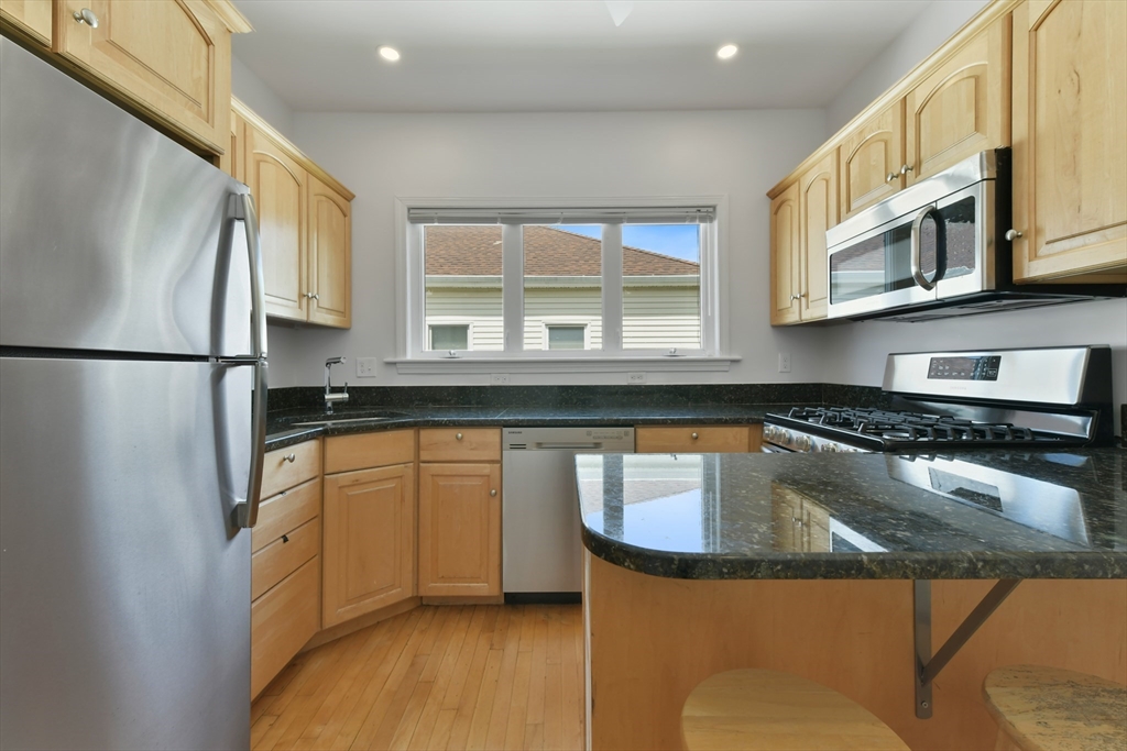 a kitchen with stainless steel appliances granite countertop a sink stove and refrigerator