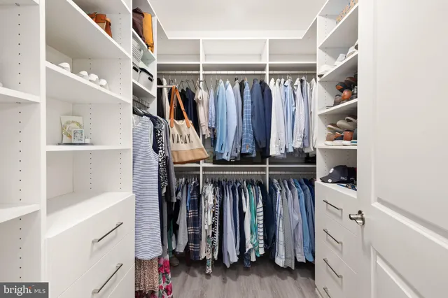 a view of walk in closet with clothes and shoes