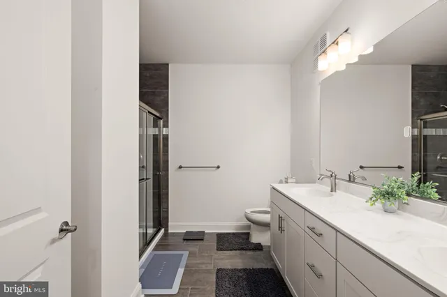 a bathroom with a double vanity sink mirror and toilet