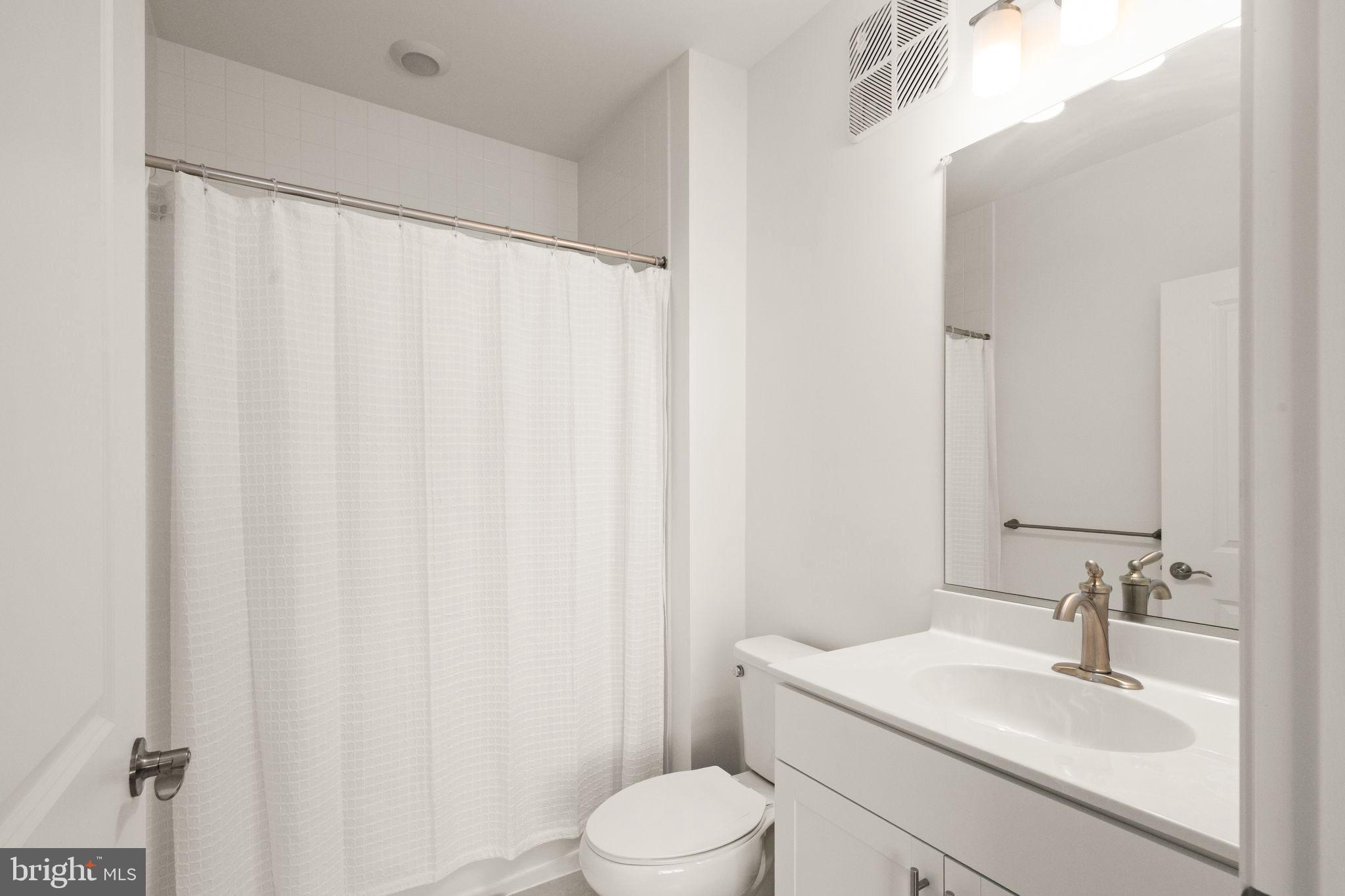 406 Bold Ruler Court, Unit 207 Havre de Grace, MD 21078 - Photo 25 of 57 a bathroom with a sink a toilet and shower curtain
