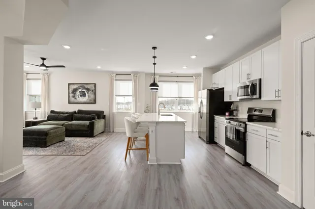 a kitchen with a refrigerator cabinets and wooden floor