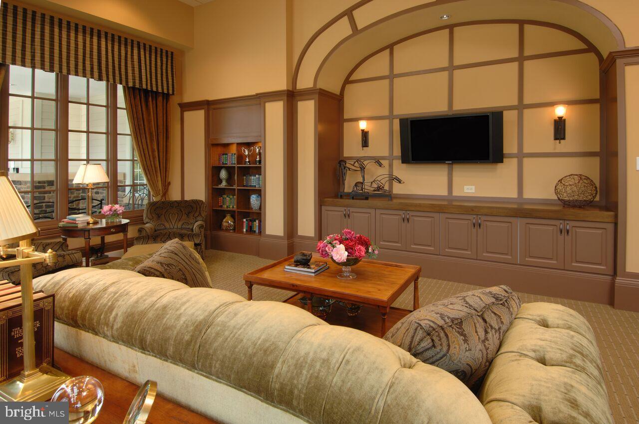 406 Bold Ruler Court, Unit 207 Havre de Grace, MD 21078 - Photo 41 of 57 a living room with furniture a flat screen tv and a floor to ceiling window