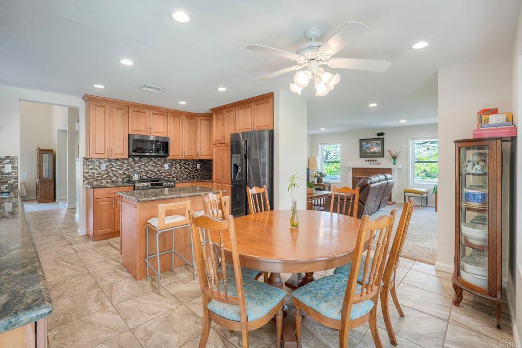 13639 Freeport Road San Diego, CA 92129 - Photo 18 of 44 a kitchen with stainless steel appliances kitchen island granite countertop a refrigerator a stove top oven a dining table and chairs