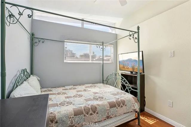 a bedroom with a bed and a flat tv screen on the dresser