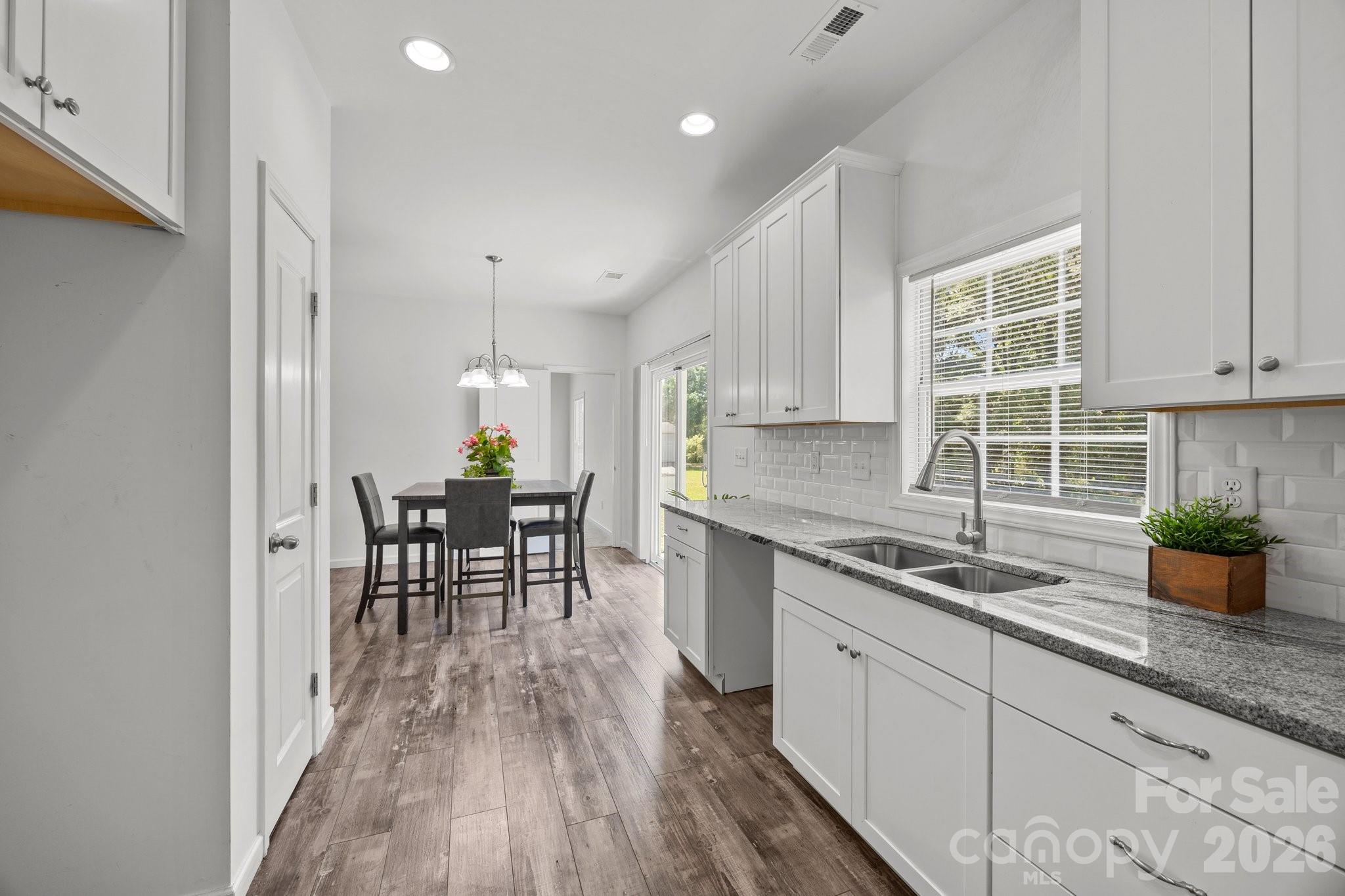 14532 East Rocky River Road Davidson, NC 28036 - Photo 21 of 32 a kitchen with granite countertop white cabinets and appliances