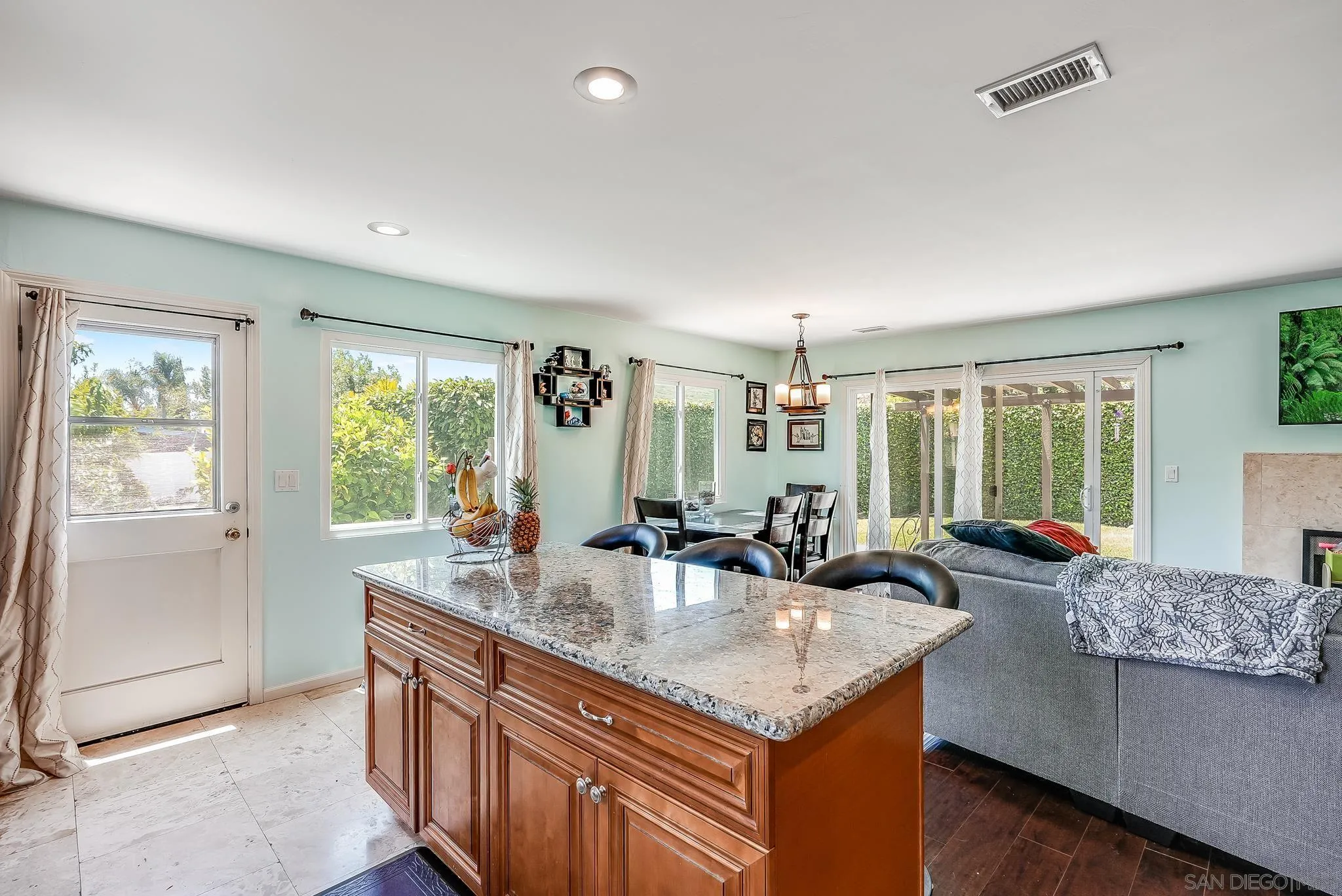 13902 Powers Road Poway, CA 92064 - Photo 11 of 32 a kitchen island with granite countertop a sink and a refrigerator