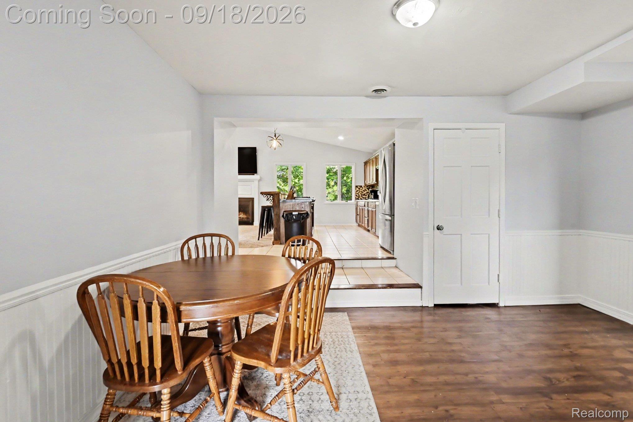 10755 Spencer Road St. Charles, MI 48655 - Photo 13 of 35 Wood-finish flooring, white paneled door, and wainscoting