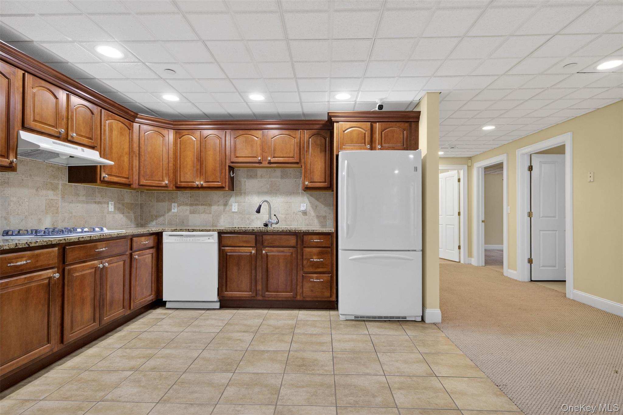 7 Farm Hollow Road New Windsor, NY 12553 - Photo 25 of 36 Kitchen with white appliances, light tile patterned floors, recessed lighting, light carpet, and wood finish cabinets
