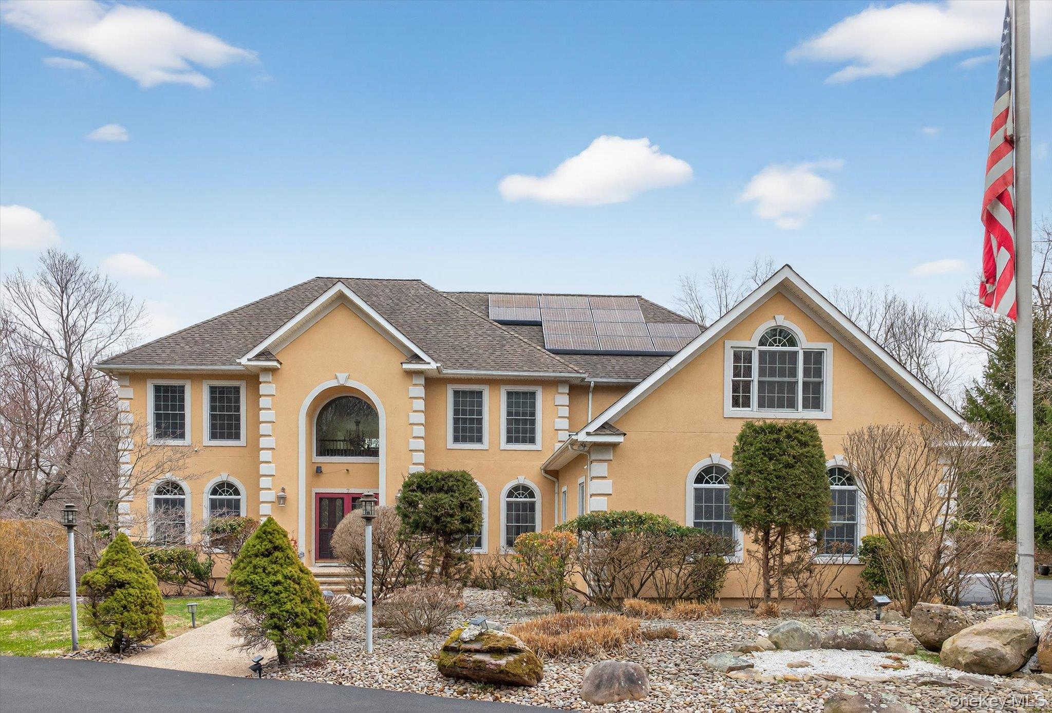 7 Farm Hollow Road New Windsor, NY 12553 - Photo 32 of 36 View of front of house with solar panels, stucco siding, and roof with shingles