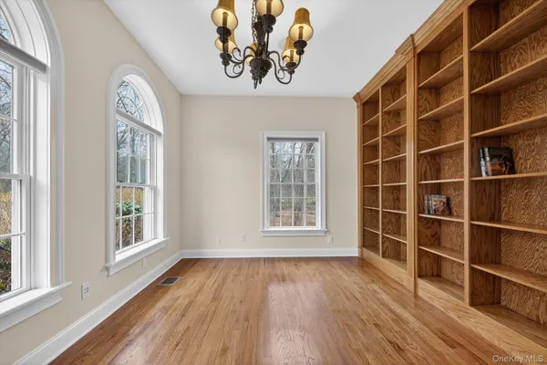 a view of a room with wooden flooring and chandelier