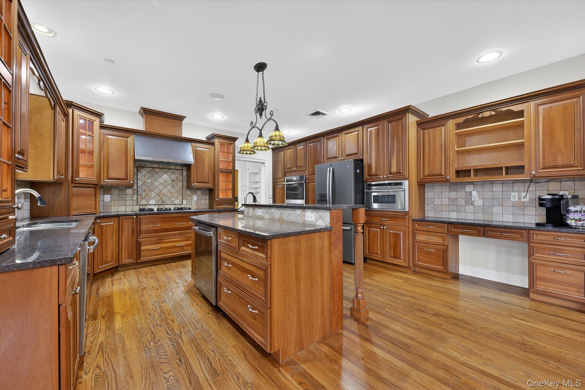 7 Farm Hollow Road New Windsor, NY 12553 - Photo 10 of 36 Kitchen with open shelves, wood finish cabinetry, a breakfast bar, dark stone countertops, and an island with sink