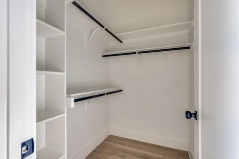 a view of walk in closet with empty racks
