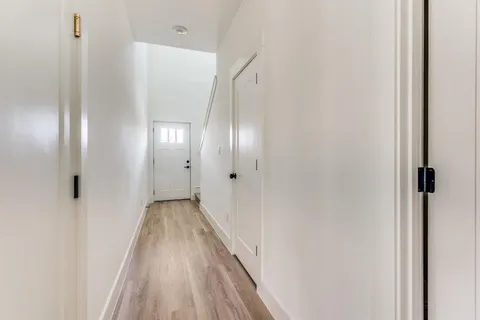 a view of a hallway with wooden floor