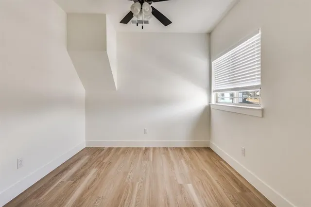 a view of a room with wooden floor and white walls