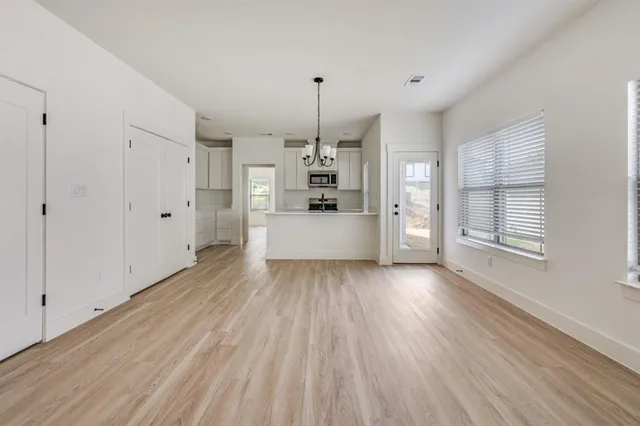 a large kitchen with cabinets wooden floor and stainless steel appliances