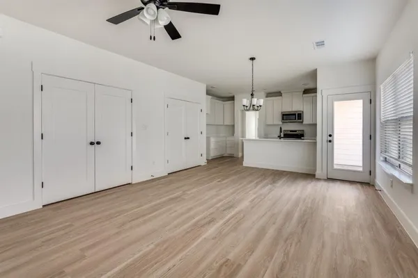 a view of a kitchen with a sink dishwasher oven window and wooden floor