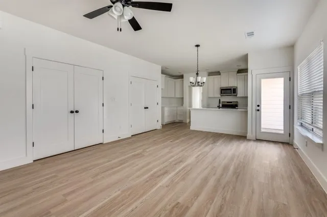 a view of a kitchen with a sink dishwasher oven window and wooden floor