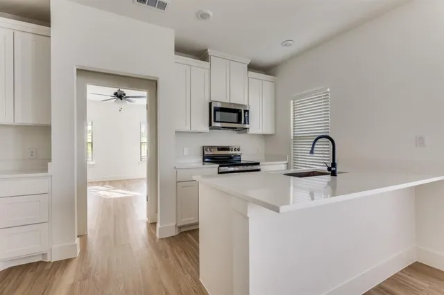 a kitchen with a refrigerator and a stove top oven