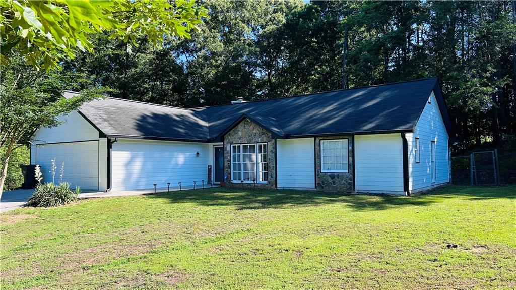 1672 Greyleaf Lane Southeast Dacula, GA 30019 - Photo 1 of 1 a view of a house with a small yard and a large tree