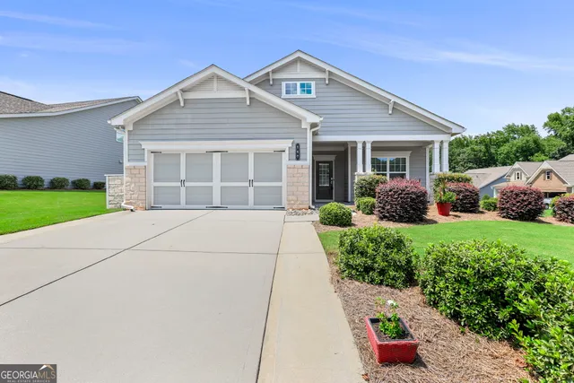 a front view of a house with a yard and potted plants