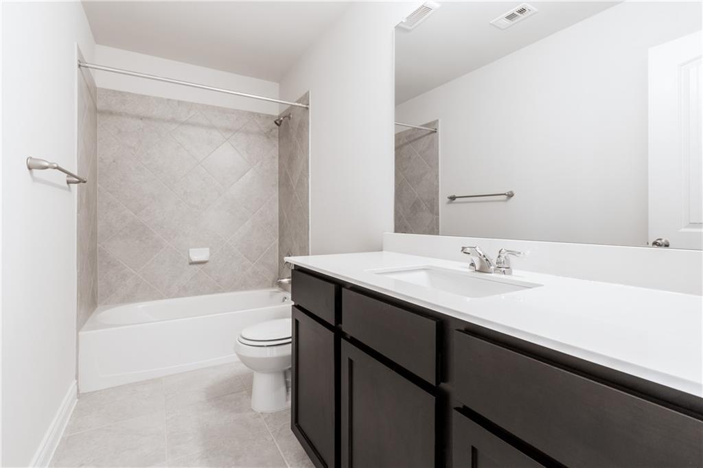 2104 Pindos Pony Way Georgetown, TX 78626 - Photo 23 of 30 A well-appointed bath features a deep soaking tub and a clean, modern vanity.