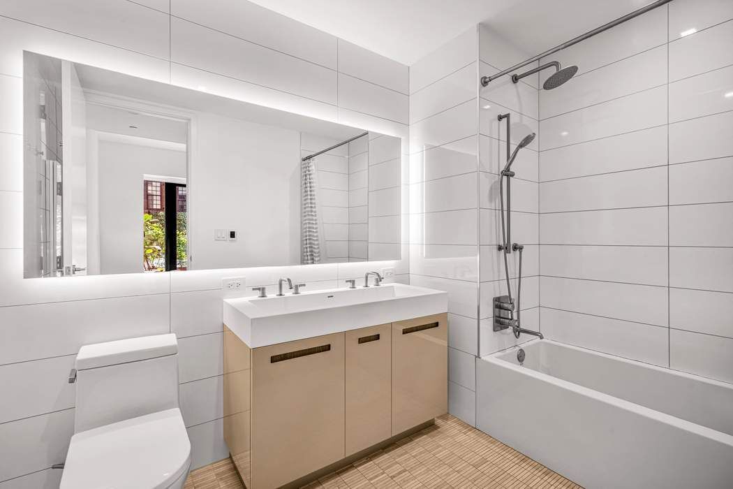 98 Front Street, Unit GRD Brooklyn, NY 11201 - Photo 8 of 23 a bathroom with a sink toilet vanity and shower