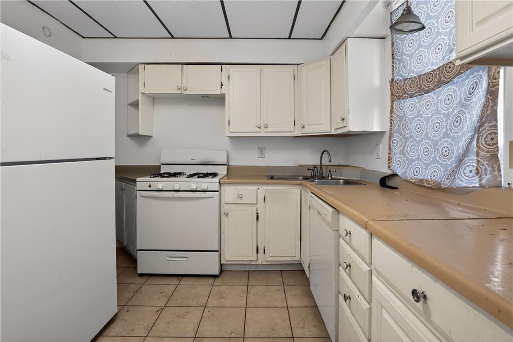 1212 Woodward Avenue McKees Rocks, PA 15136 - Photo 14 of 34 a kitchen with granite countertop white cabinets and white appliances