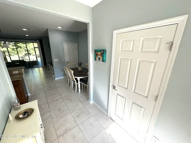 a living room with stainless steel appliances furniture a rug kitchen view and a table