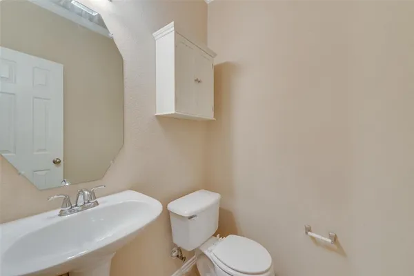 a white toilet sitting next to a bathroom sink