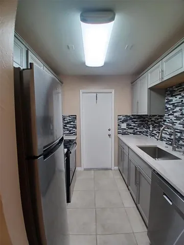 a kitchen with a refrigerator and a sink