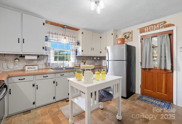 a kitchen with a refrigerator a stove a sink dishwasher with a dining table and chairs