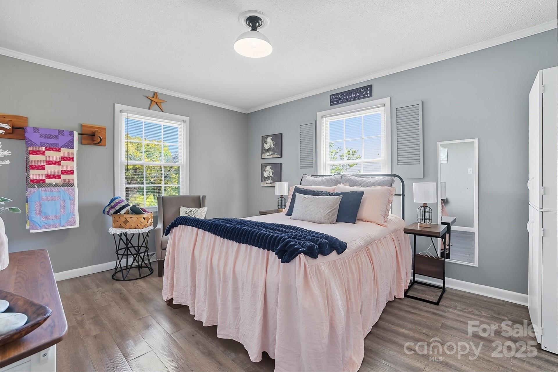 201 Airport Road Monroe, NC 28110 - Photo 22 of 47 a bedroom with a bed and a table in it with wooden floor