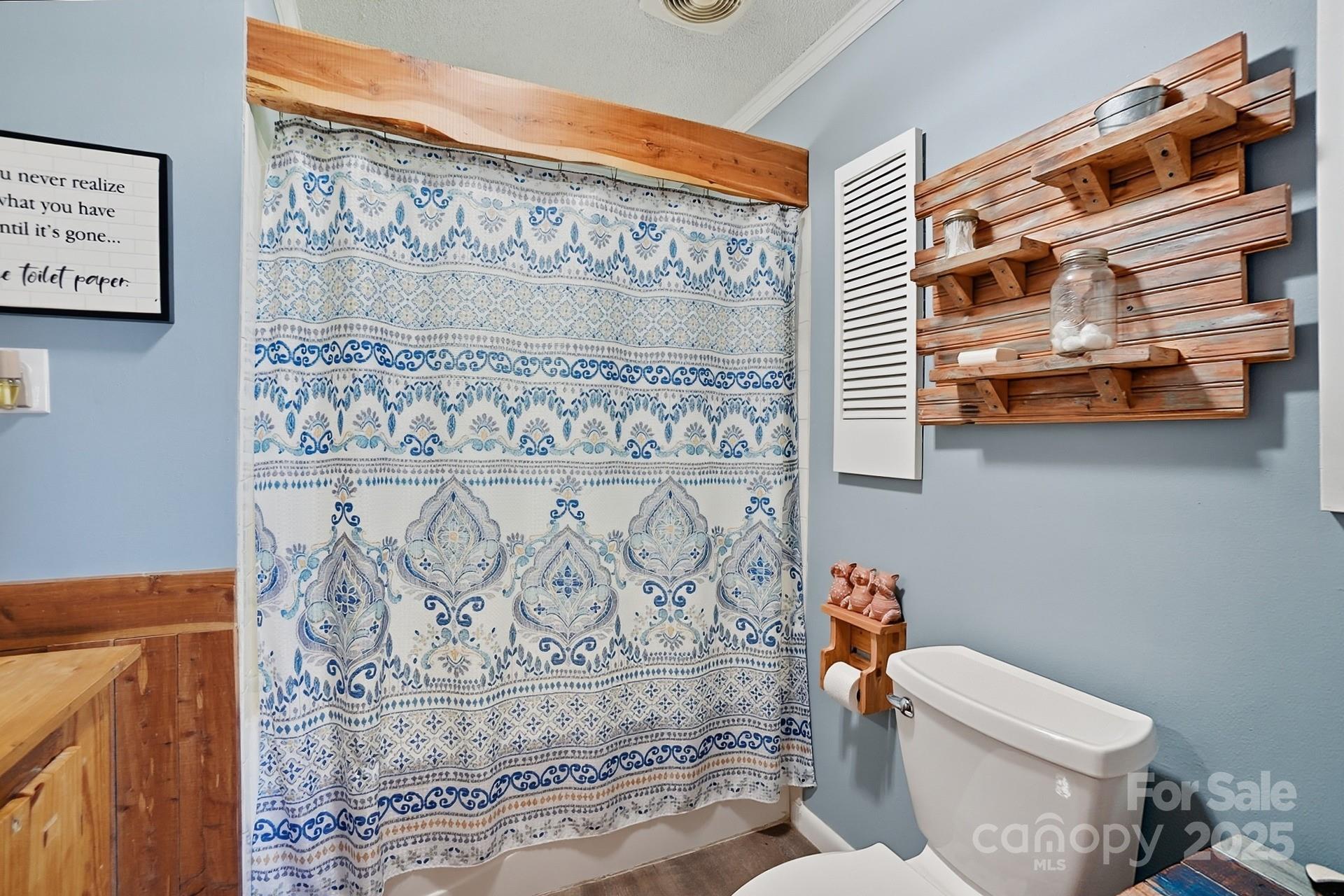 201 Airport Road Monroe, NC 28110 - Photo 25 of 47 a bathroom with a toilet and a shower curtain
