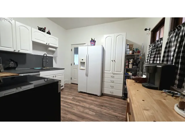 a kitchen with stainless steel appliances kitchen island granite countertop a refrigerator oven a sink with wooden cabinets