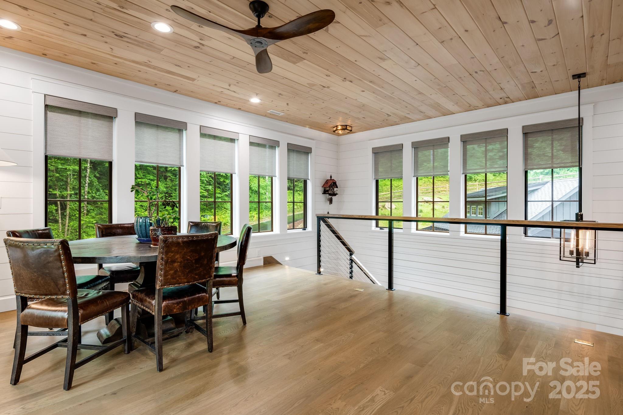 1416 East Clubhouse Road, Unit 73 Sylva, NC 28779 - Photo 25 of 48 a view of a dining room with furniture large windows and wooden floor
