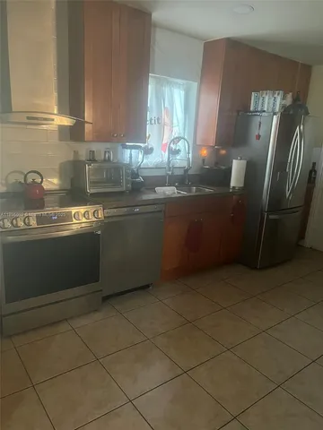 a kitchen with stainless steel appliances granite countertop a sink and a refrigerator