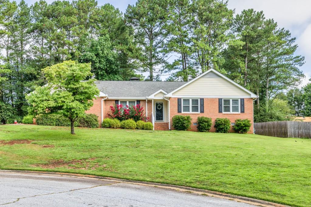a front of a house with a yard and green space