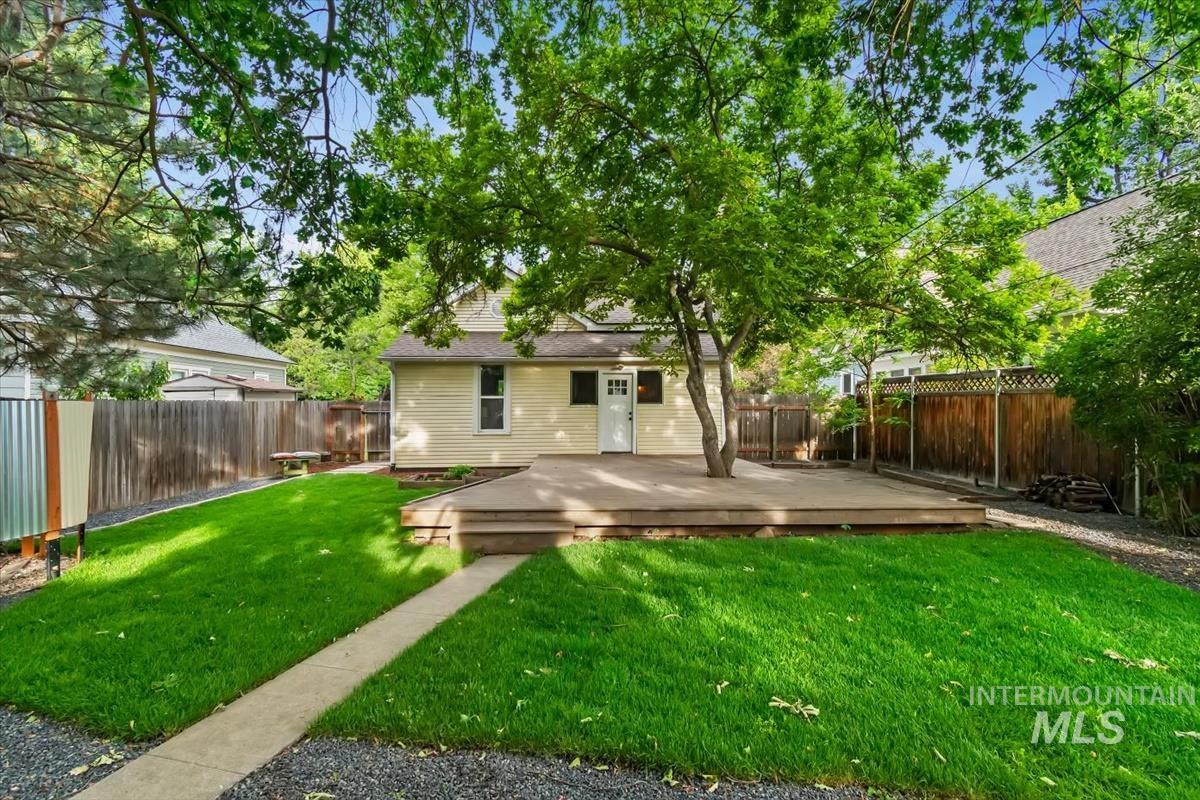 910 North 16th Street Boise, ID 83702 - Photo 34 of 47 Expansive backyard featuring a manicured lawn, concrete pathway, and a multi-level wood deck with an integrated mature tree