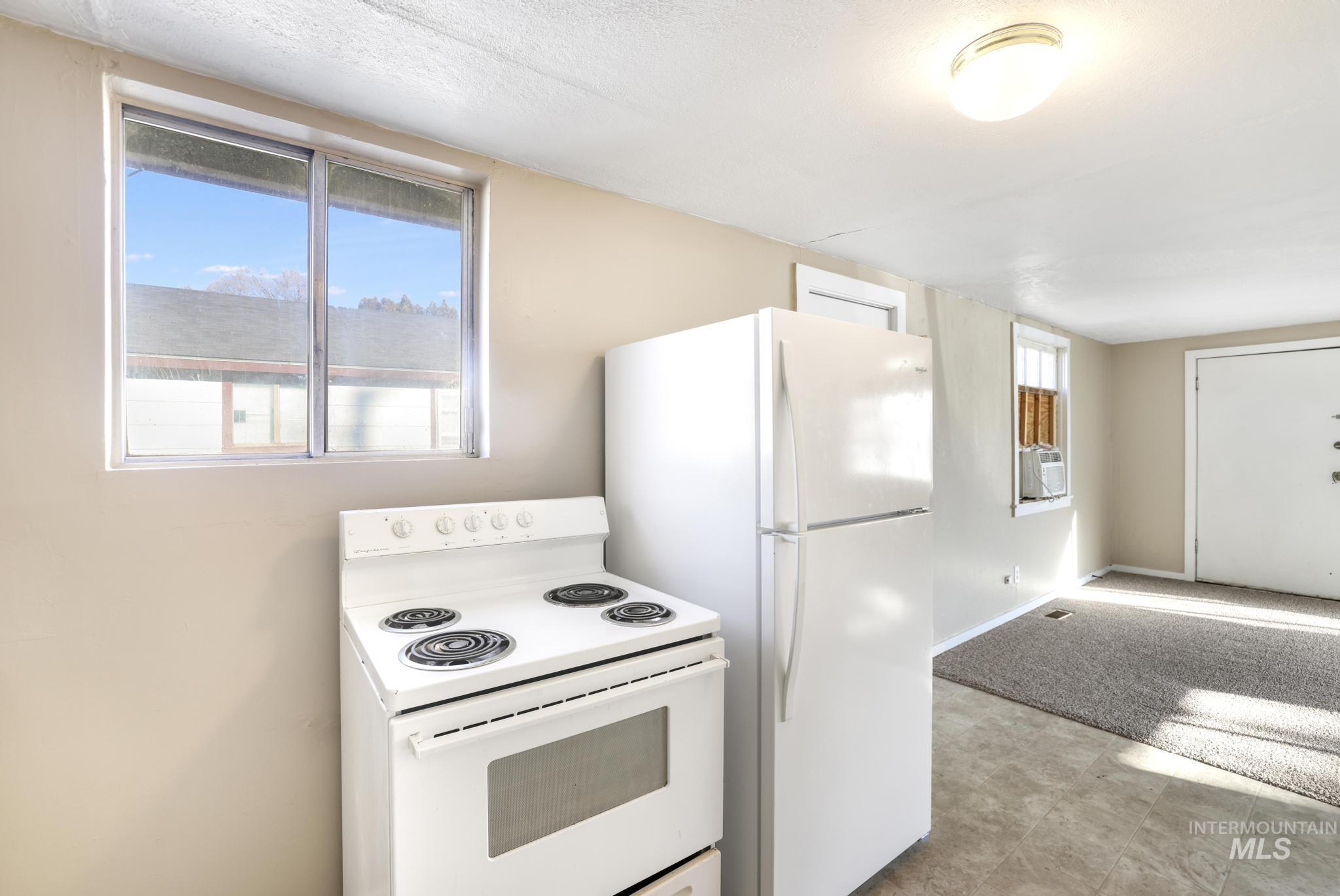 525 Adams Street Twin Falls, ID 83301 - Photo 14 of 31 Kitchen with white range with electric stovetop, a textured ceiling, and light flooring