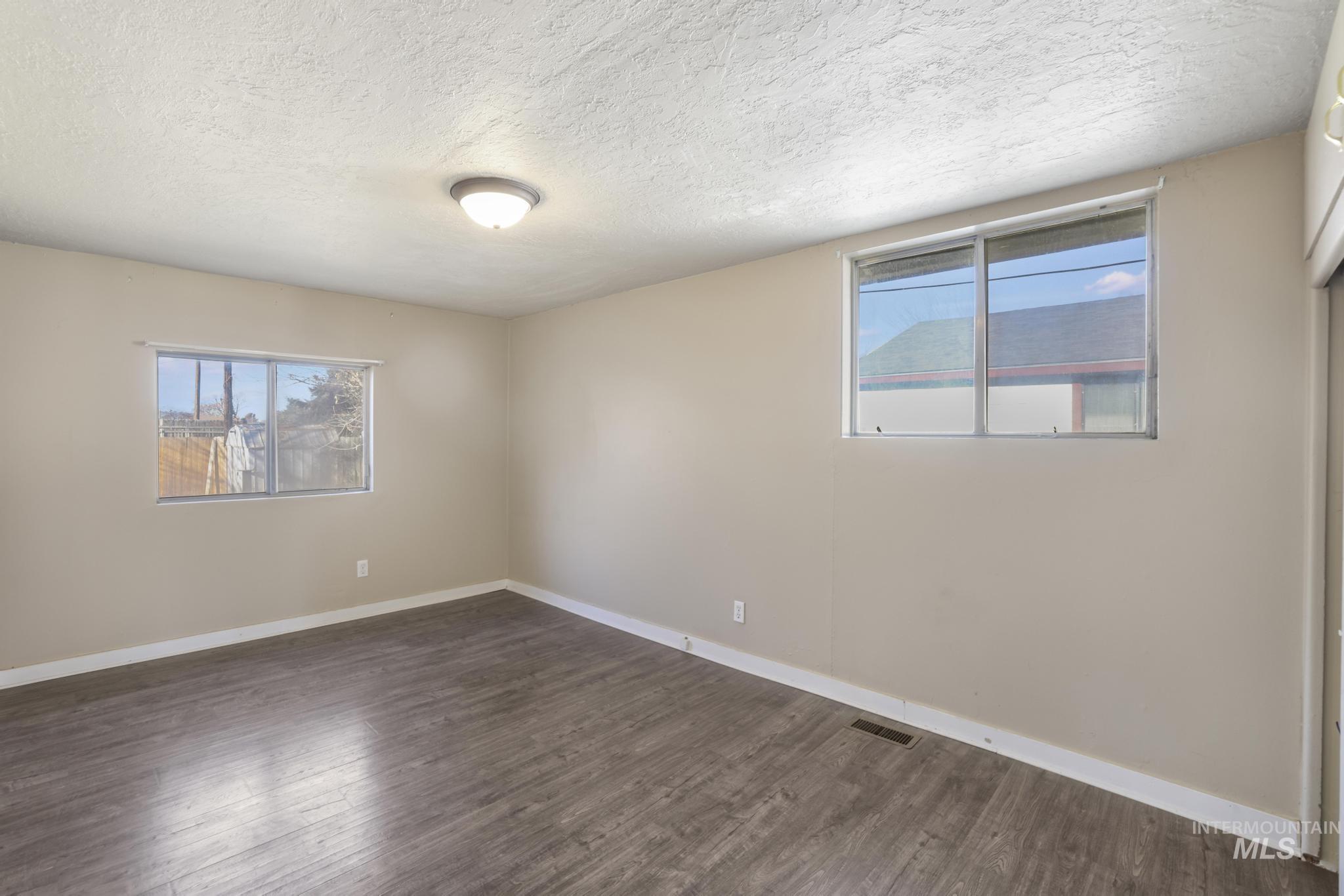 525 Adams Street Twin Falls, ID 83301 - Photo 17 of 31 Unfurnished room featuring a textured ceiling and dark wood-style floors