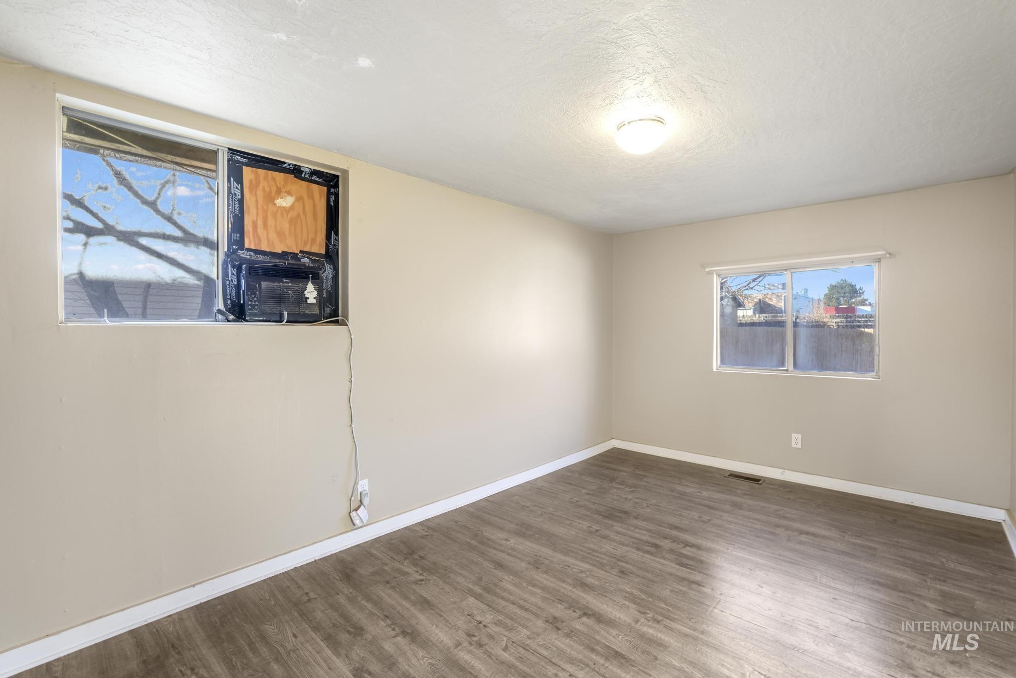 525 Adams Street Twin Falls, ID 83301 - Photo 19 of 31 Unfurnished room featuring healthy amount of natural light, wood finished floors, and a textured ceiling
