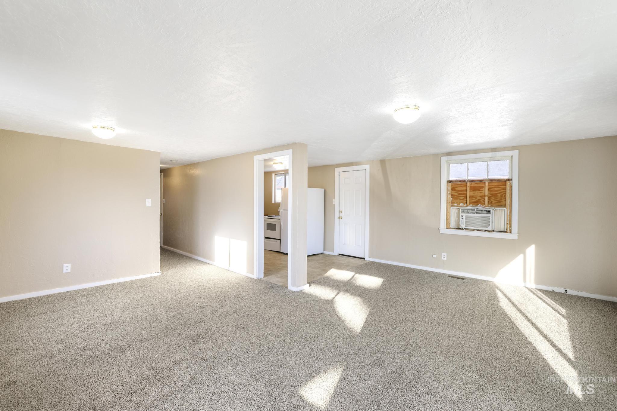 525 Adams Street Twin Falls, ID 83301 - Photo 8 of 31 Carpeted empty room featuring baseboards and a textured ceiling