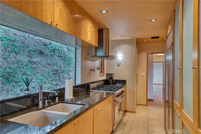 a kitchen with stainless steel appliances granite countertop a sink stove and refrigerator