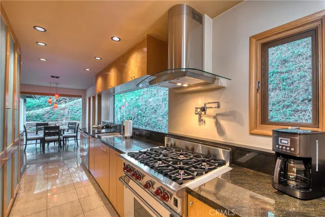 a kitchen with stainless steel appliances granite countertop a stove a sink and a dining table